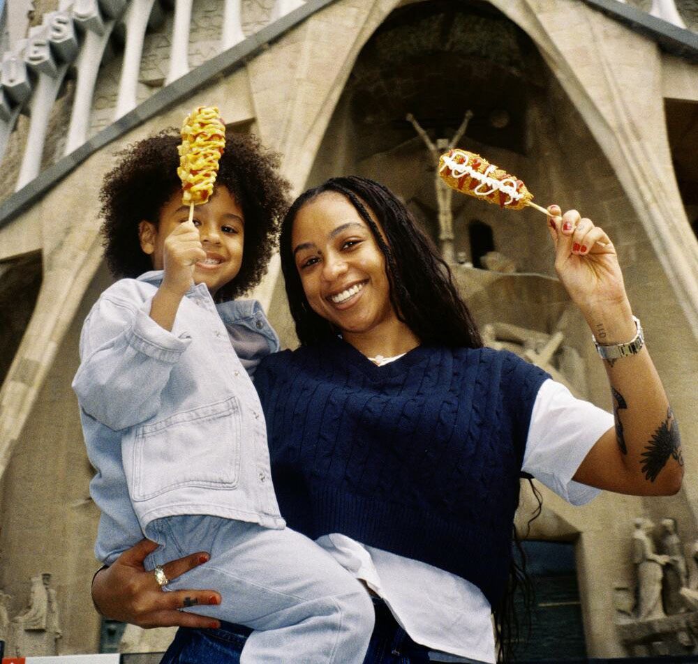 Turistas disfrutando de Korndogs de House of Korndogs frente a la Sagrada Família en Barcelona